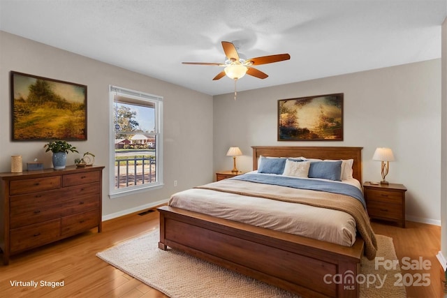bedroom with baseboards, a ceiling fan, and light wood-style floors