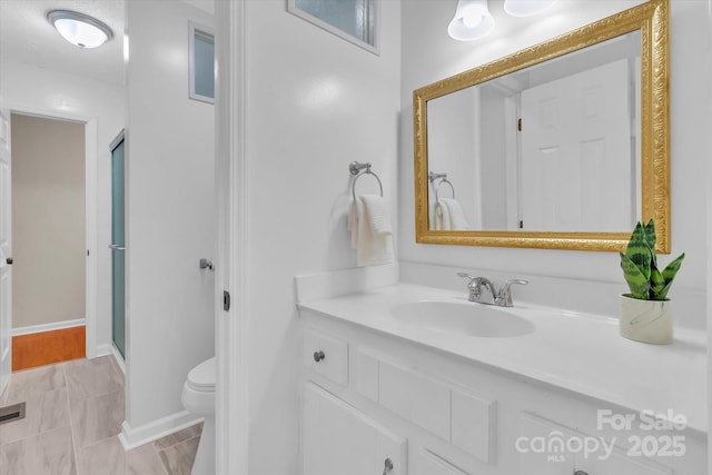 bathroom with visible vents, a stall shower, baseboards, toilet, and vanity