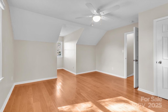 bonus room with a ceiling fan, baseboards, lofted ceiling, and light wood-style floors