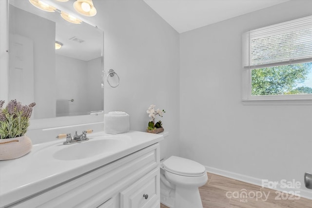 bathroom with visible vents, baseboards, toilet, wood finished floors, and vanity
