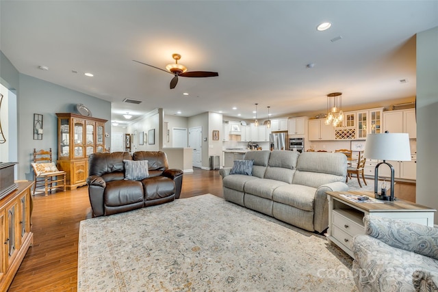 living room with light hardwood / wood-style floors and ceiling fan