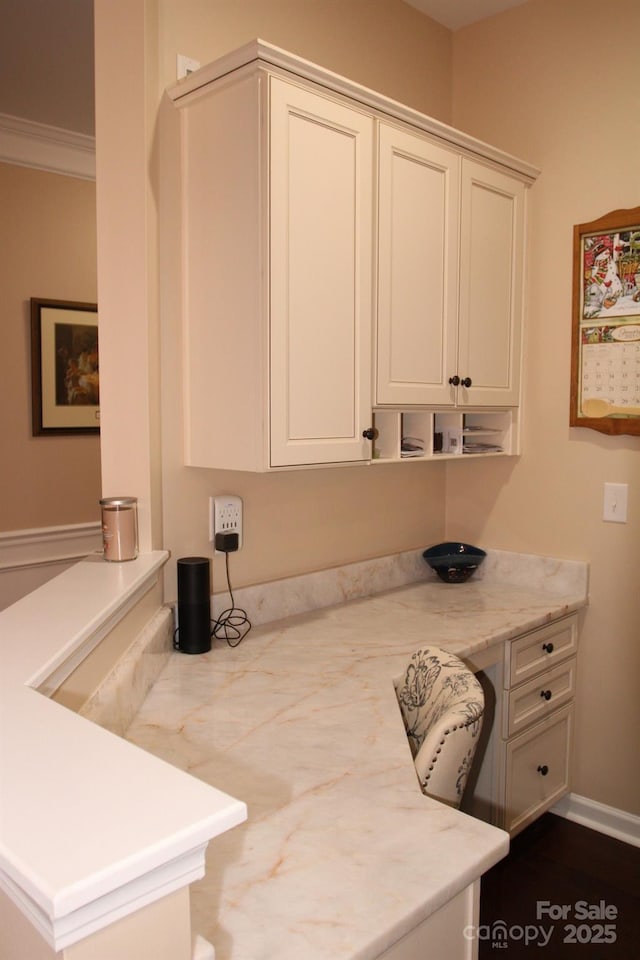 kitchen with white cabinetry and light stone countertops