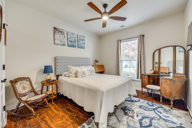 bedroom featuring dark wood-type flooring, ceiling fan, and multiple windows