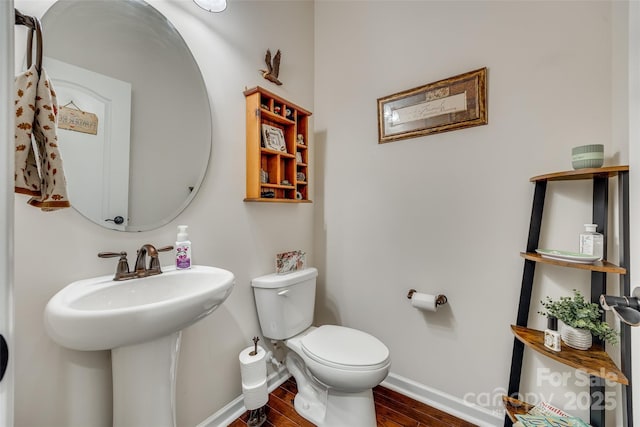 bathroom featuring toilet, wood-type flooring, and sink