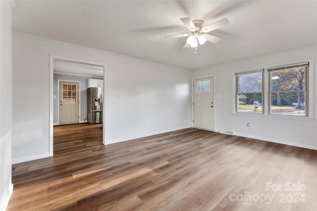 unfurnished room featuring ceiling fan, dark hardwood / wood-style flooring, and crown molding