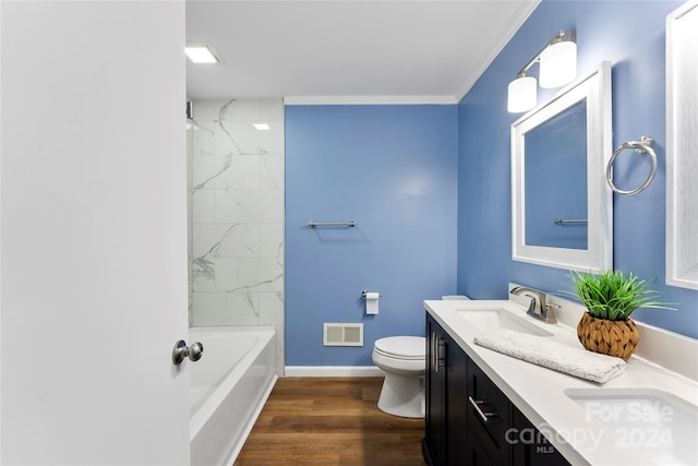 full bathroom featuring tiled shower / bath combo, vanity, crown molding, hardwood / wood-style floors, and toilet