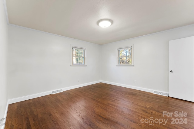 unfurnished room featuring wood-type flooring, crown molding, and a healthy amount of sunlight