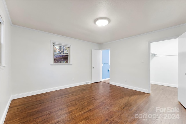 spare room with hardwood / wood-style flooring and crown molding