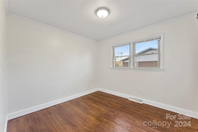 unfurnished room featuring wood-type flooring and ornamental molding