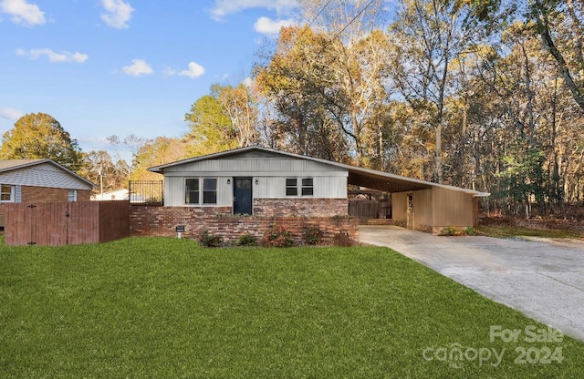 ranch-style house featuring a front lawn and a carport