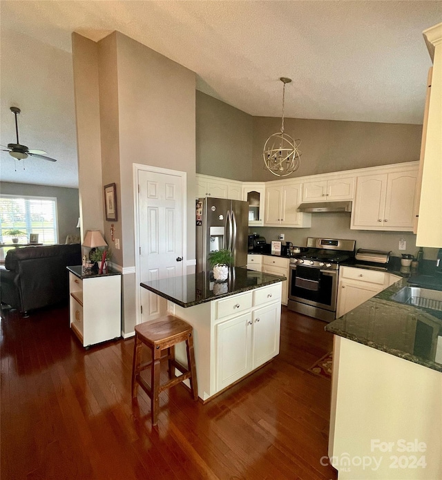 kitchen featuring appliances with stainless steel finishes, ceiling fan with notable chandelier, dark wood-type flooring, and pendant lighting