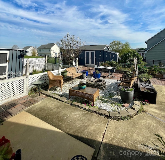 view of patio / terrace featuring an outbuilding and an outdoor living space with a fire pit