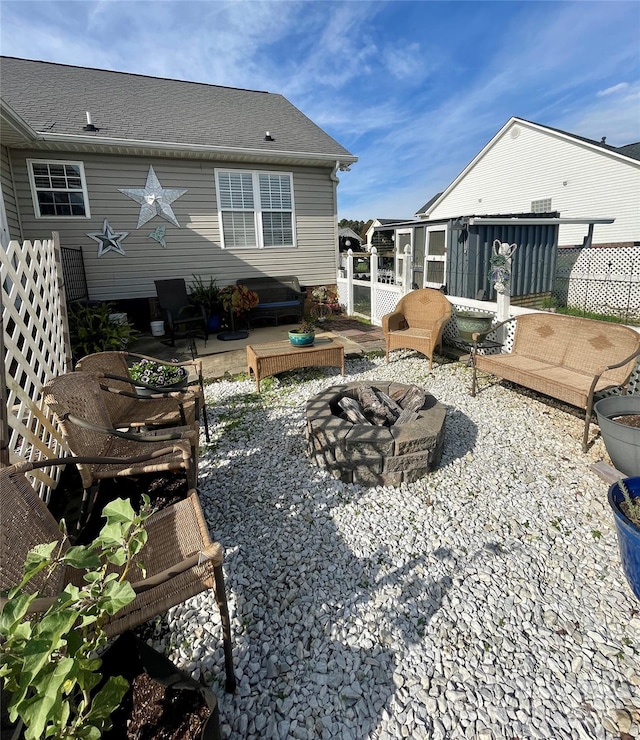 rear view of property featuring a fire pit and a patio area