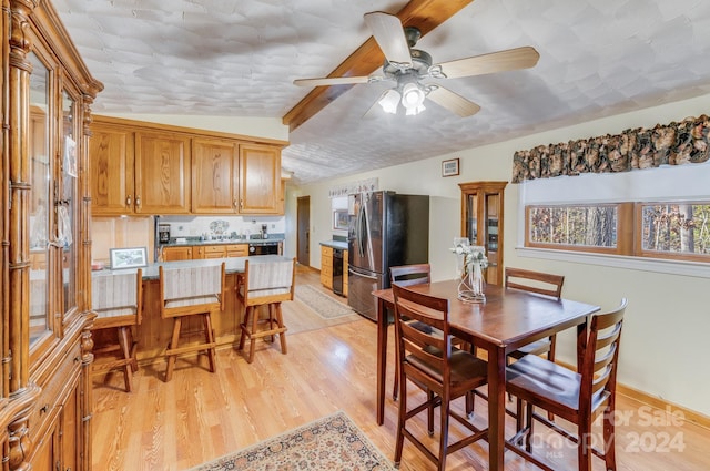 dining space featuring vaulted ceiling with beams, light wood-type flooring, and ceiling fan