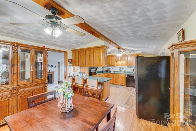 dining area featuring vaulted ceiling with beams and light hardwood / wood-style floors