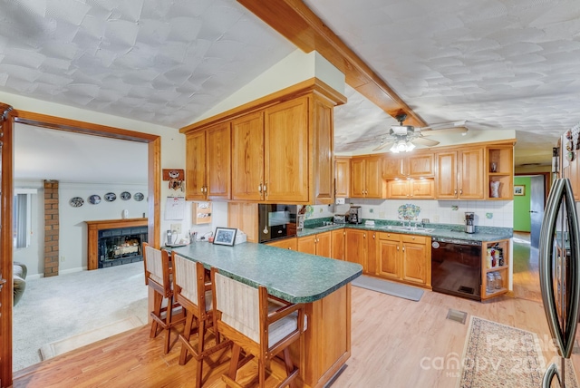 kitchen featuring dishwasher, lofted ceiling with beams, ceiling fan, light hardwood / wood-style floors, and stainless steel refrigerator