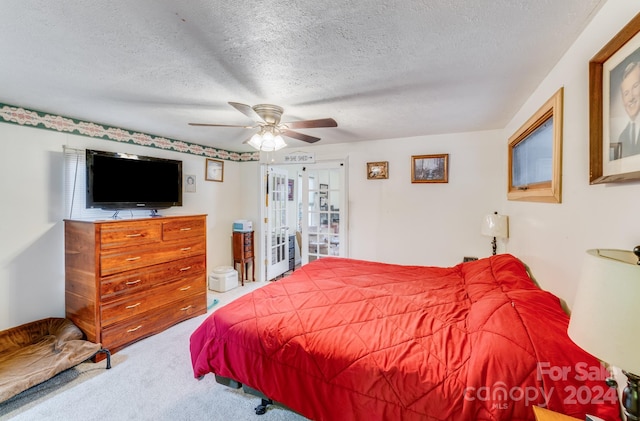 carpeted bedroom featuring a textured ceiling and ceiling fan