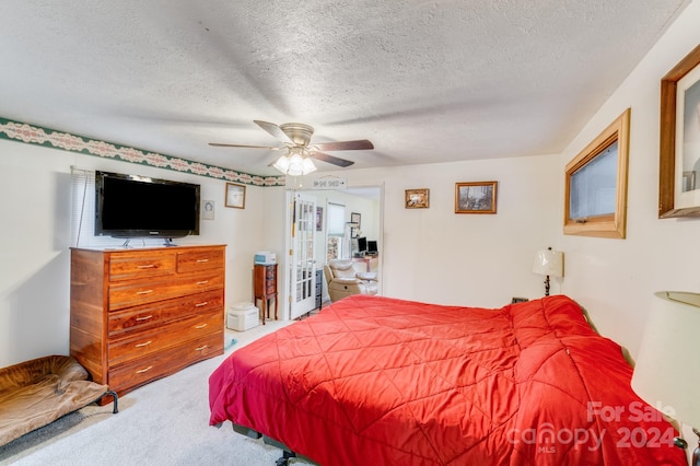 carpeted bedroom featuring a textured ceiling and ceiling fan