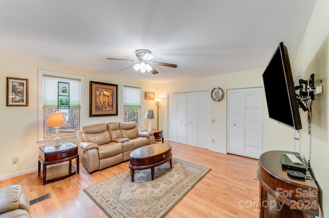 living room with ceiling fan and light hardwood / wood-style flooring