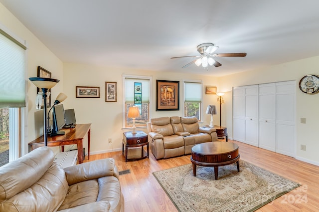 living room featuring light wood-type flooring, plenty of natural light, and ceiling fan