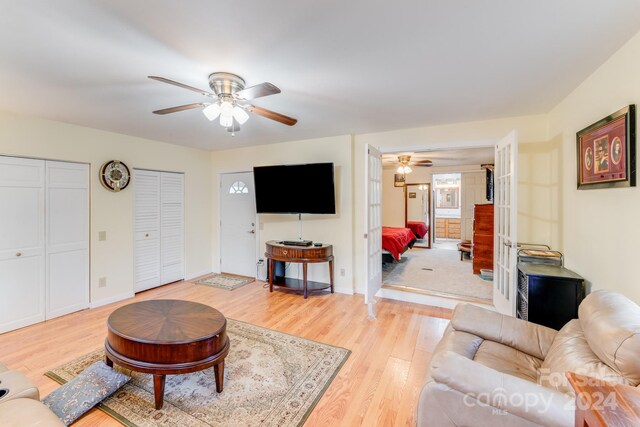 living room featuring ceiling fan, french doors, and light wood-type flooring