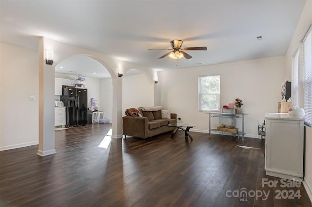 living room featuring ceiling fan and dark hardwood / wood-style flooring