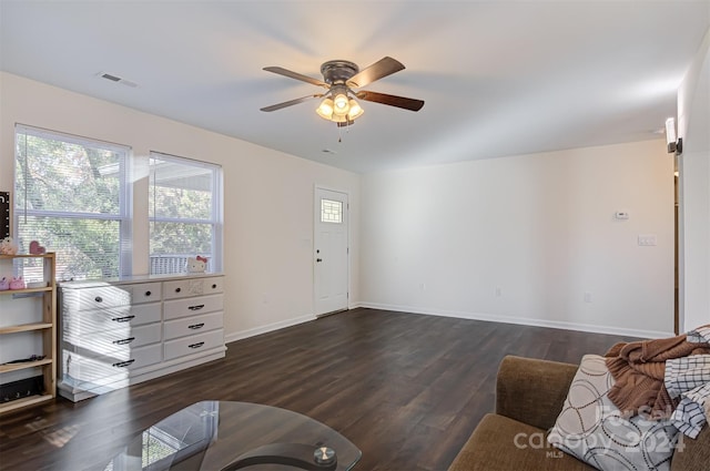 living room featuring ceiling fan and dark wood-type flooring