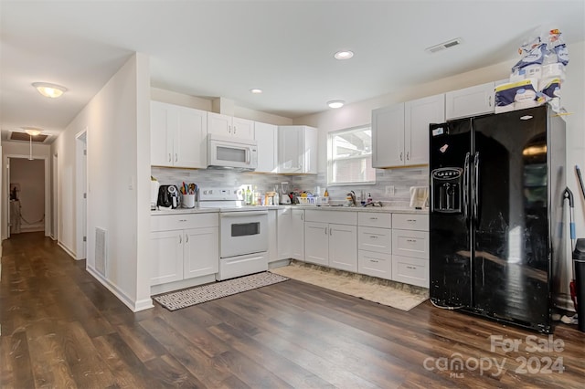 kitchen with white cabinets, dark hardwood / wood-style flooring, and white appliances