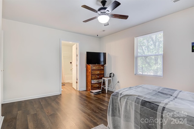 bedroom with ensuite bath, ceiling fan, and dark hardwood / wood-style flooring