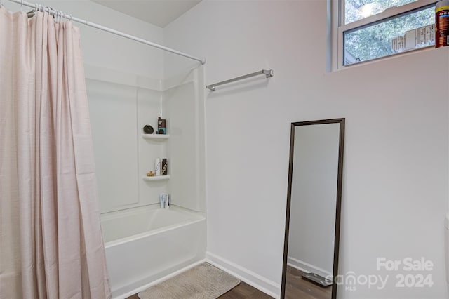 bathroom featuring wood-type flooring and shower / bath combination with curtain