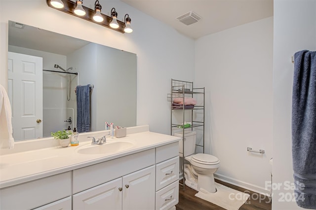 bathroom with walk in shower, toilet, vanity, and hardwood / wood-style flooring