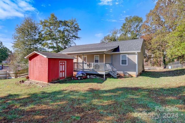 rear view of house with a lawn and a shed