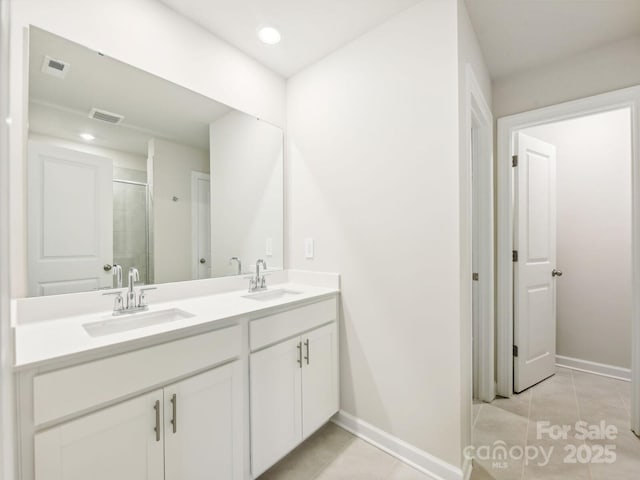 bathroom featuring tile patterned floors, vanity, and a shower with shower door