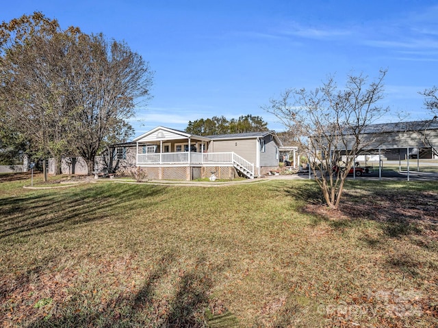 back of house featuring covered porch and a yard