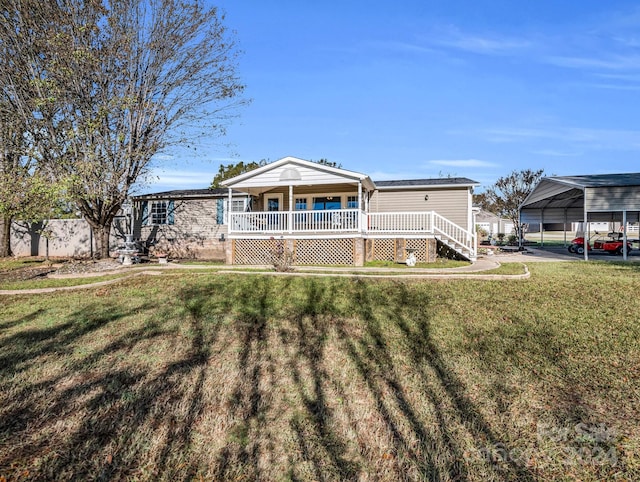 rear view of house featuring a carport, covered porch, and a yard