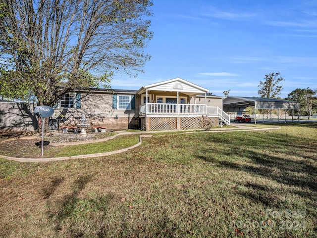 view of front of home featuring covered porch, a front yard, and a carport