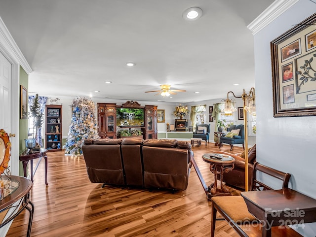 living room with ceiling fan, light hardwood / wood-style floors, and crown molding