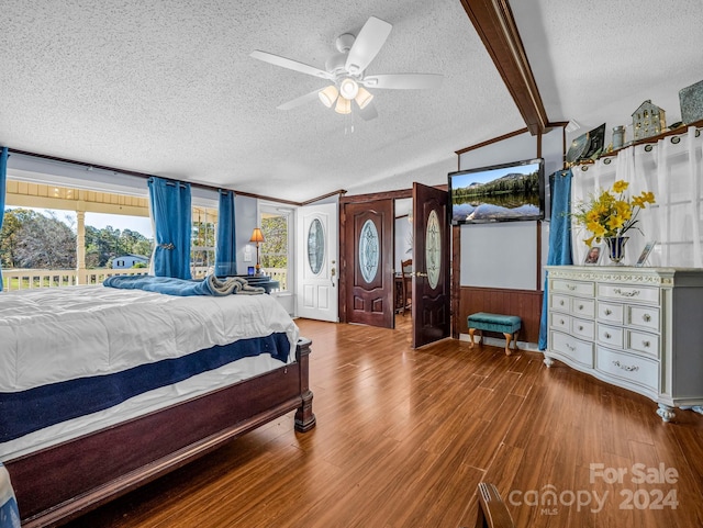 bedroom featuring ceiling fan, vaulted ceiling with beams, a textured ceiling, wooden walls, and hardwood / wood-style flooring