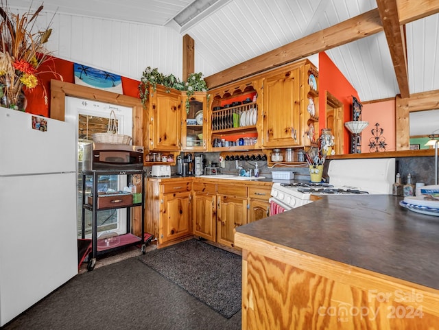 kitchen with sink, lofted ceiling with beams, white appliances, and dark carpet