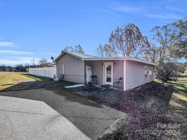 view of front of house featuring cooling unit and a front lawn