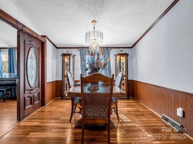 226 Mcswain Rd, Forest City, NC 28043 - dining area with wainscoting, a textured ceiling, a chandelier, wooden walls, and crown molding