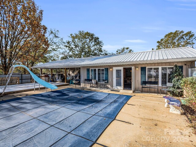 226 Mcswain Rd, Forest City, NC 28043 - back of property featuring a patio, a covered pool, metal roof, and board and batten siding
