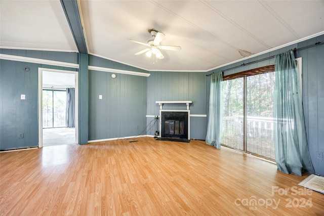 unfurnished living room with wood-type flooring, vaulted ceiling with beams, plenty of natural light, and ceiling fan