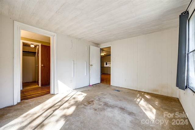 unfurnished bedroom with wood walls and a closet