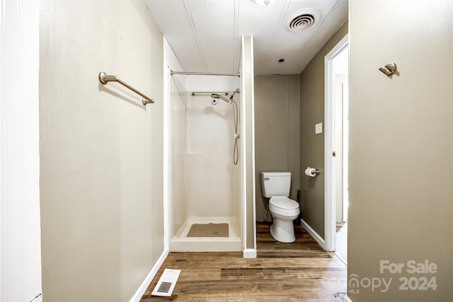 bathroom with a shower, wood-type flooring, and toilet