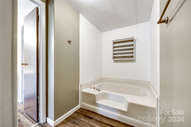 bathroom featuring wood-type flooring and a tub