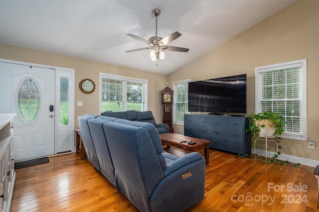 living room featuring light hardwood / wood-style floors, vaulted ceiling, and ceiling fan