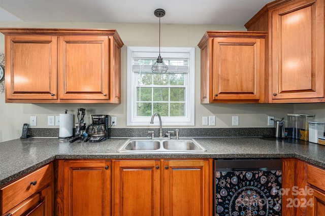 kitchen featuring sink, black dishwasher, and hanging light fixtures