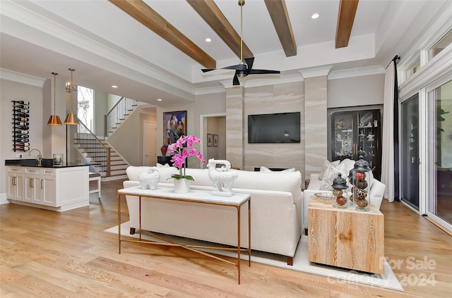 living room featuring light hardwood / wood-style floors, crown molding, and beam ceiling