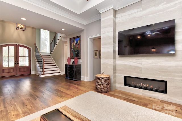 foyer entrance featuring crown molding, french doors, hardwood / wood-style floors, and tile walls